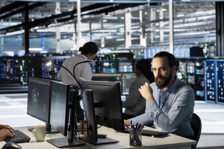 IT professional monitoring dashboards in a modern operations centre for managed data platform and SAP support
